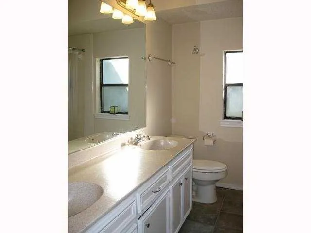 a bathroom with a sink toilet and mirror