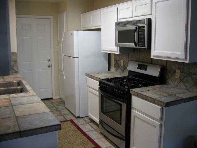 7801 Parliament Place Austin, TX 78759 - Photo 3 of 4 a kitchen with a stove microwave and refrigerator