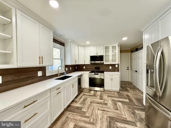 a kitchen with granite countertop a refrigerator and a sink