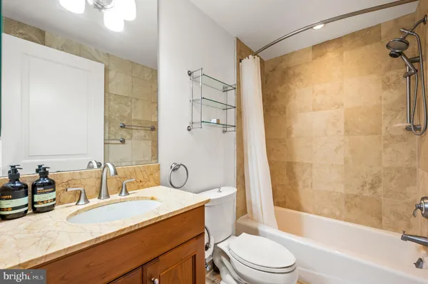 a bathroom with a granite countertop sink toilet and shower