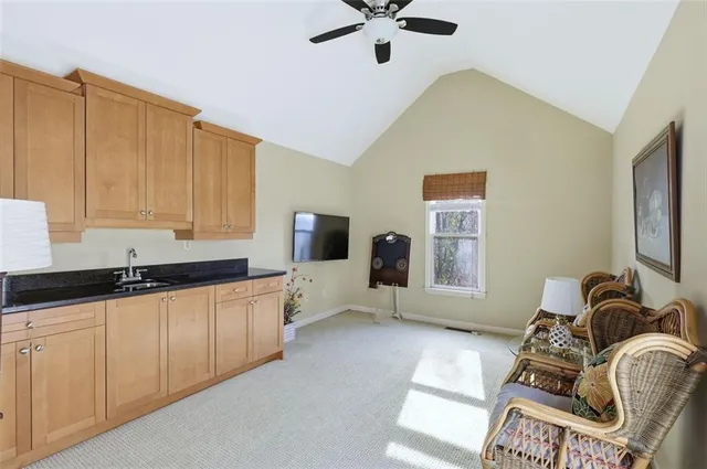 an empty room with ceiling fan and windows