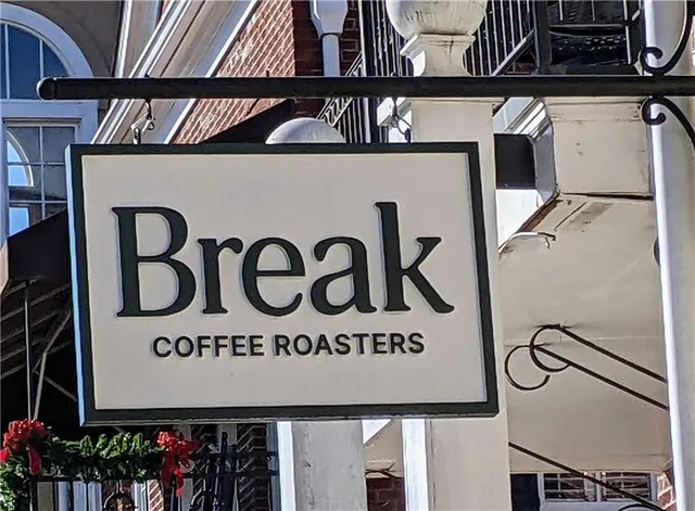 a view of a swimming pool with lawn chairs and a large tree