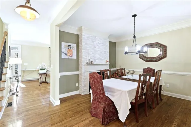 a dining room with furniture a chandelier and wooden floor