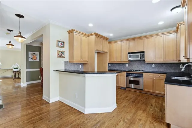 a kitchen with stainless steel appliances granite countertop a stove a sink and a microwave