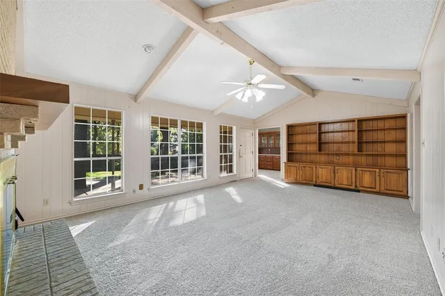a view of an empty room with a fireplace and a window