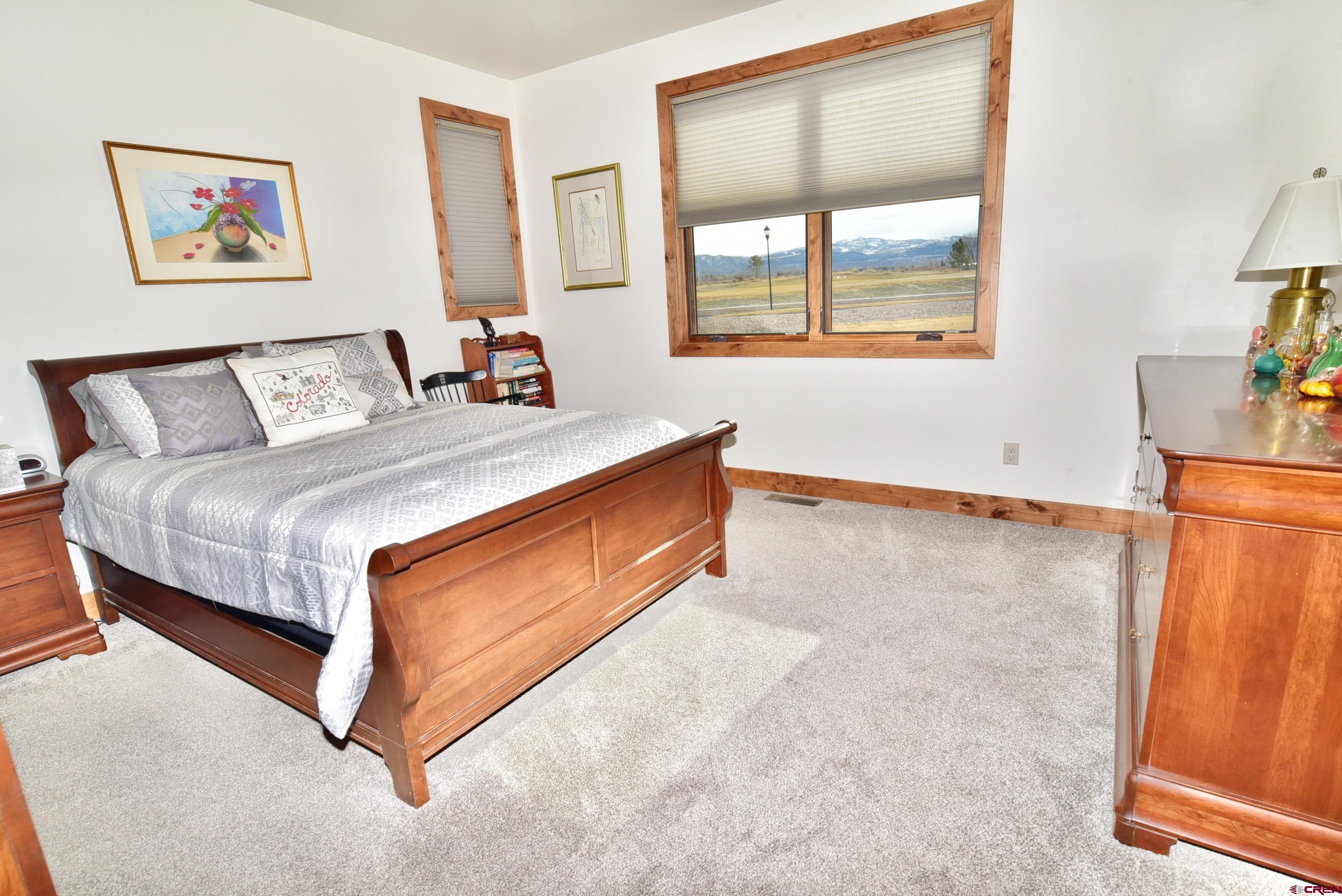 2136 Signature Ridge Lane Montrose, CO 81401 - Photo 23 of 32 a bed room with a bed and a painting on the wall