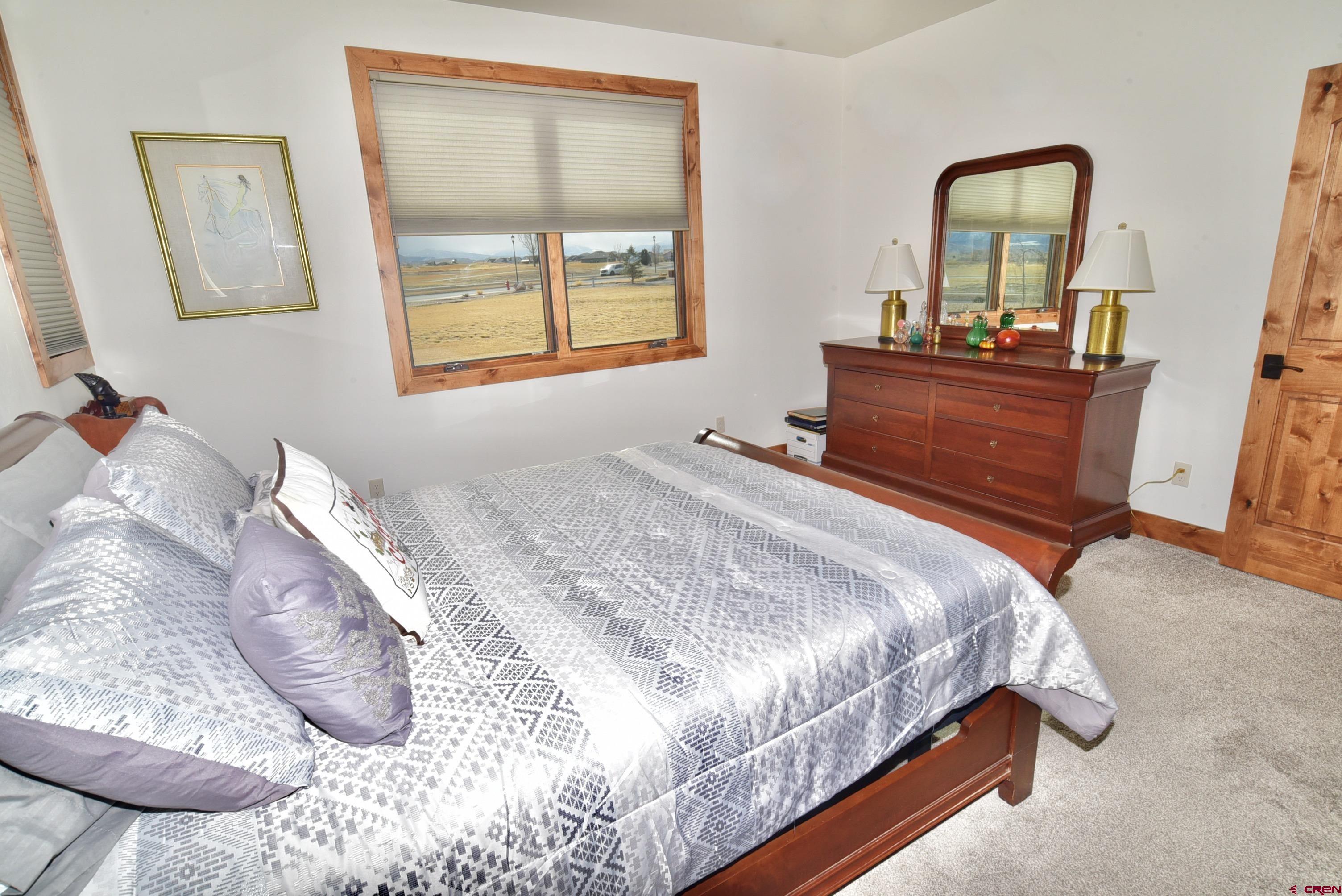 2136 Signature Ridge Lane Montrose, CO 81401 - Photo 24 of 32 a bedroom with a bed and a window