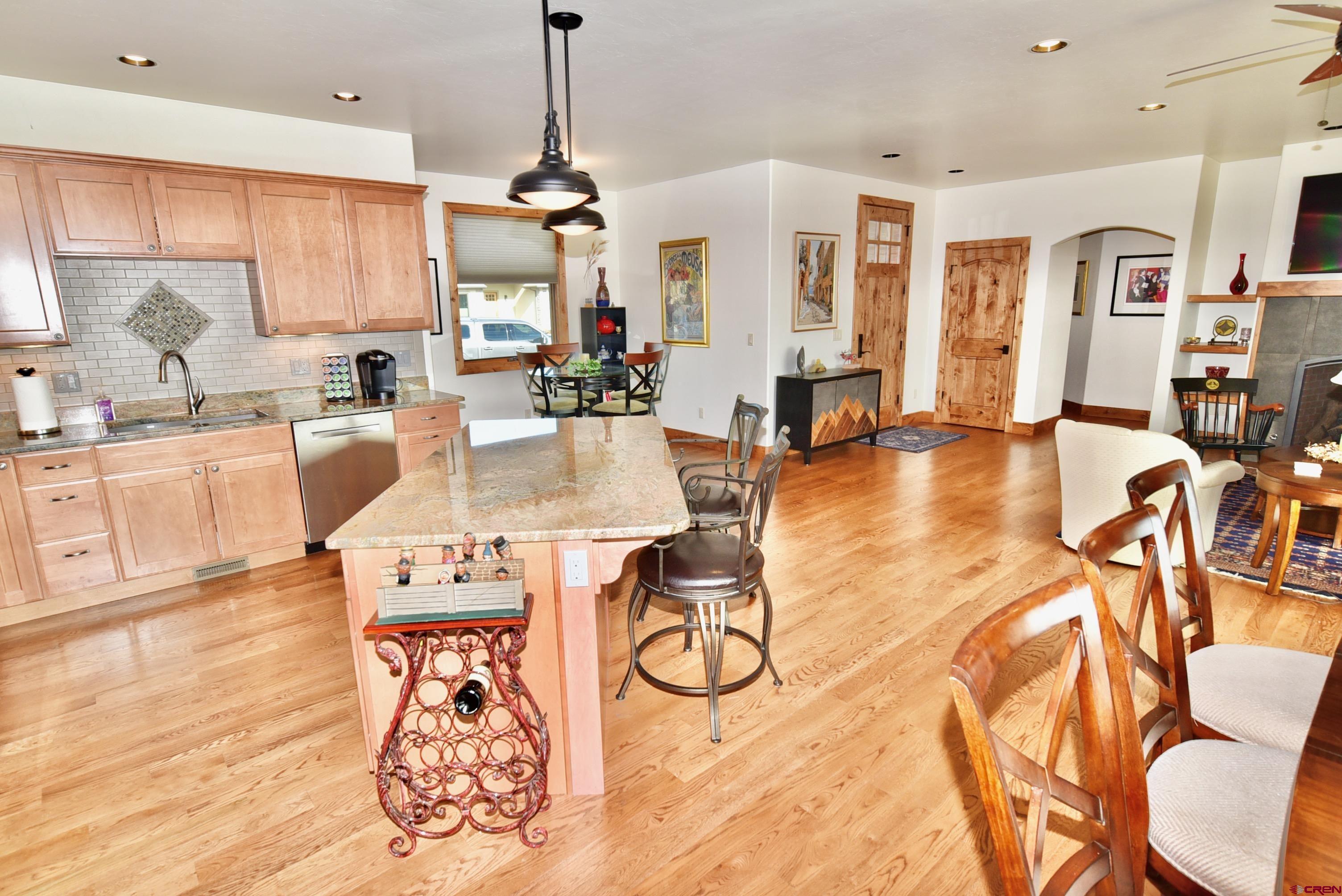 2136 Signature Ridge Lane Montrose, CO 81401 - Photo 9 of 32 a view of a dining room and livingroom with furniture wooden floor a chandelier