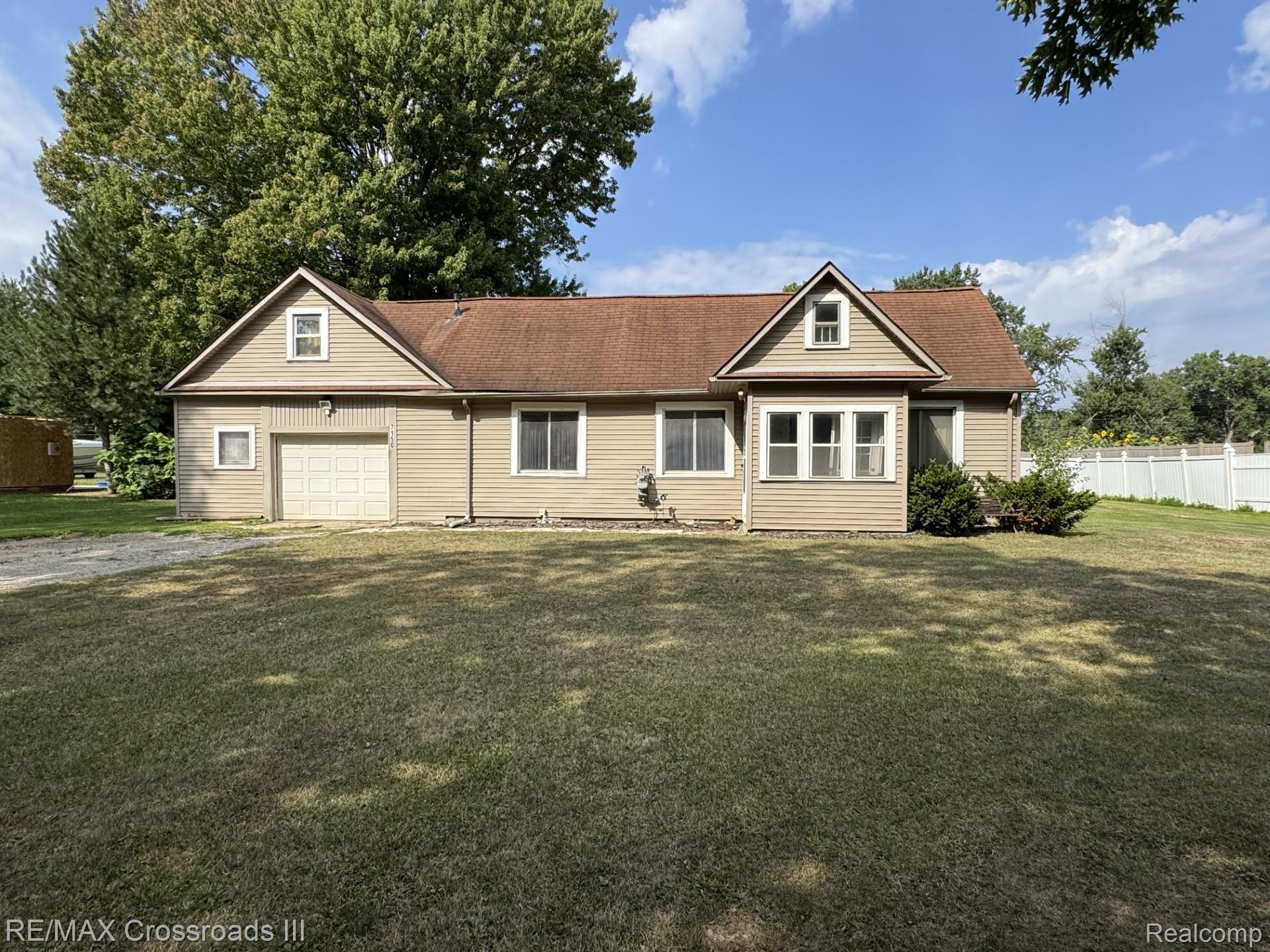 7150 Sheldon Road Belleville, MI 48111 - Photo 1 of 11 Single-story residence with dormer windows, attached garage, and light-colored siding