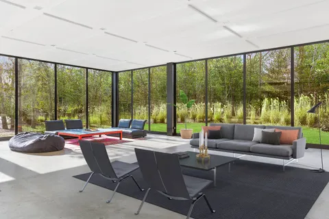 a living room with furniture and floor to ceiling windows
