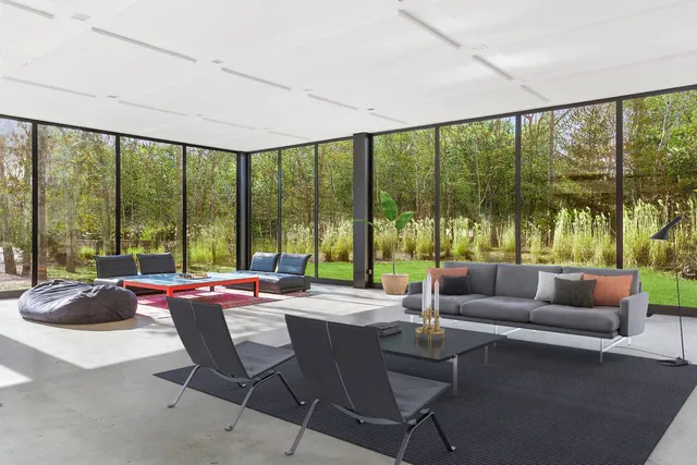 a living room with furniture and floor to ceiling windows