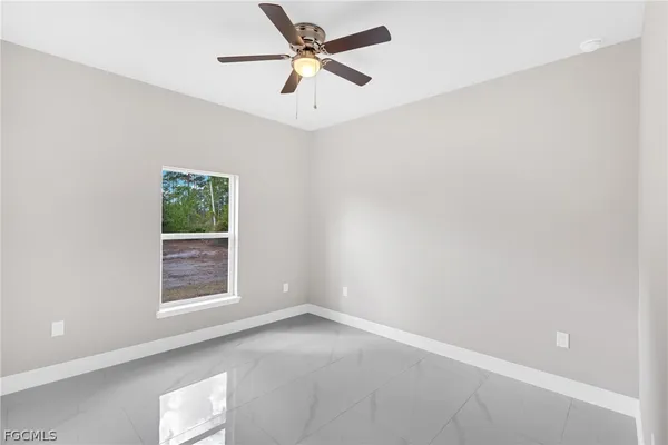 an empty room with a window and a fan