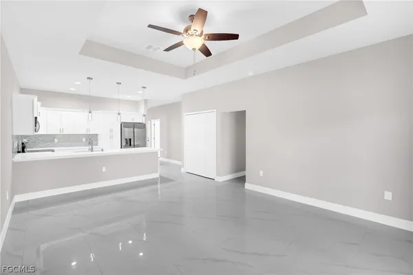 a view of an empty room with a kitchen