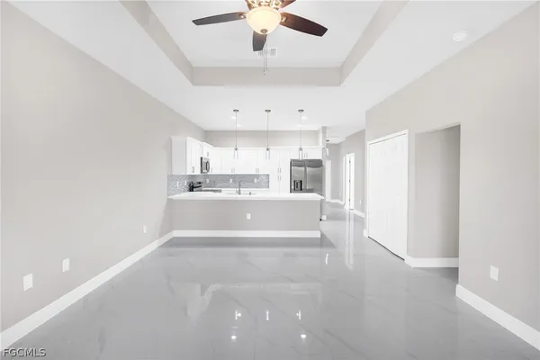 a large white kitchen with a large window stainless steel appliances and cabinets