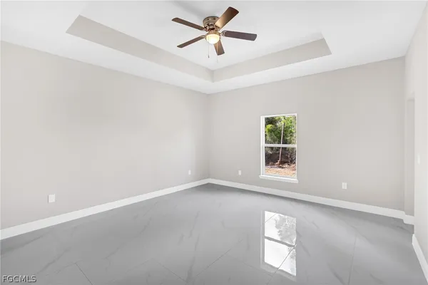 an empty room with windows and fan