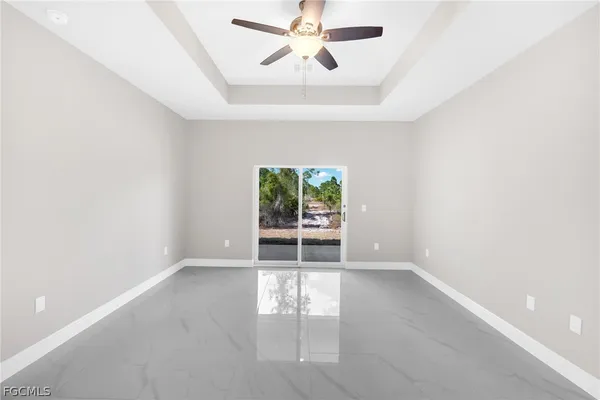 an empty room with windows and ceiling fan