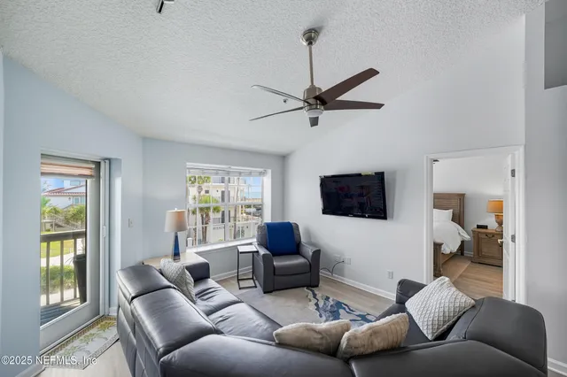 a living room with furniture a flat screen tv and a window