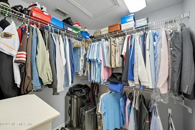 a view of walk in closet with clothes
