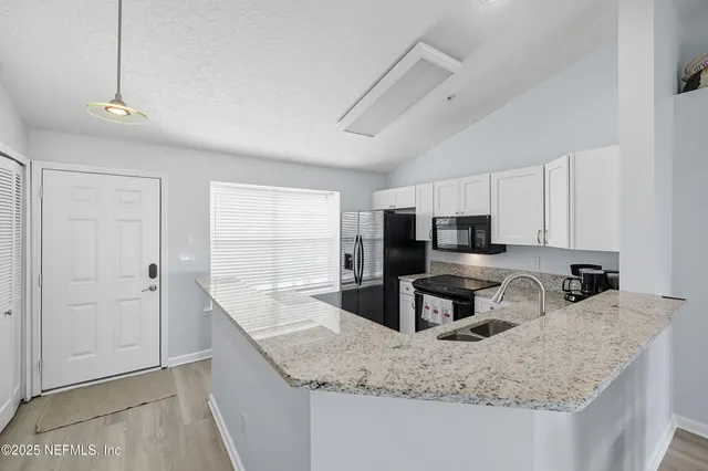 a kitchen with stainless steel appliances granite countertop a sink a stove and a refrigerator
