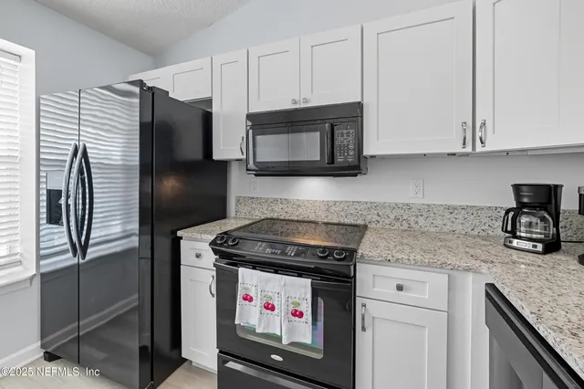 a kitchen with stainless steel appliances granite countertop a stove microwave and refrigerator