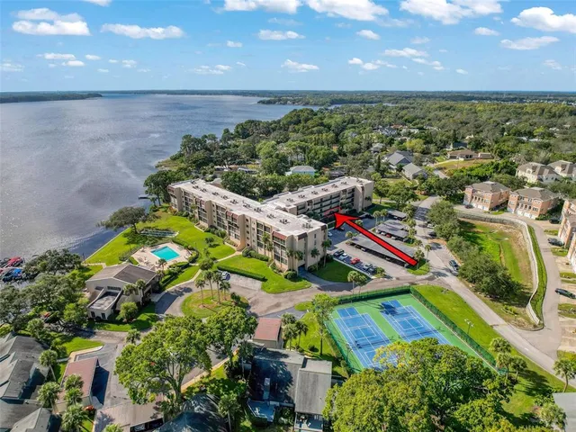 an aerial view of a house with a yard and lake view