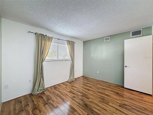 an empty room with wooden floor and a window