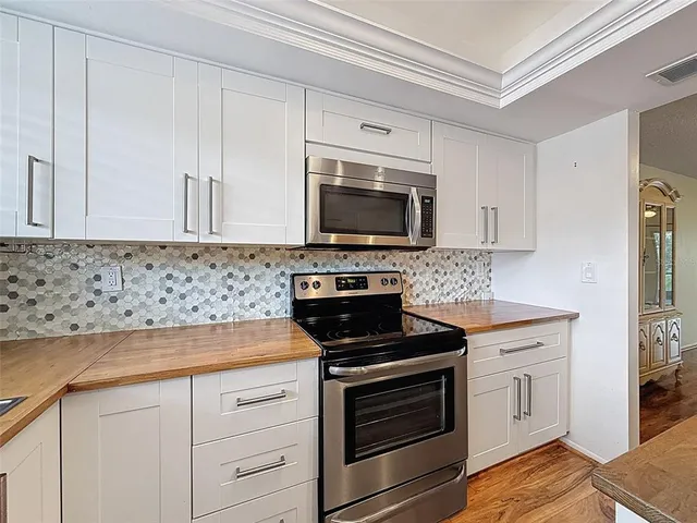 a kitchen with white cabinets stainless steel appliances and sink