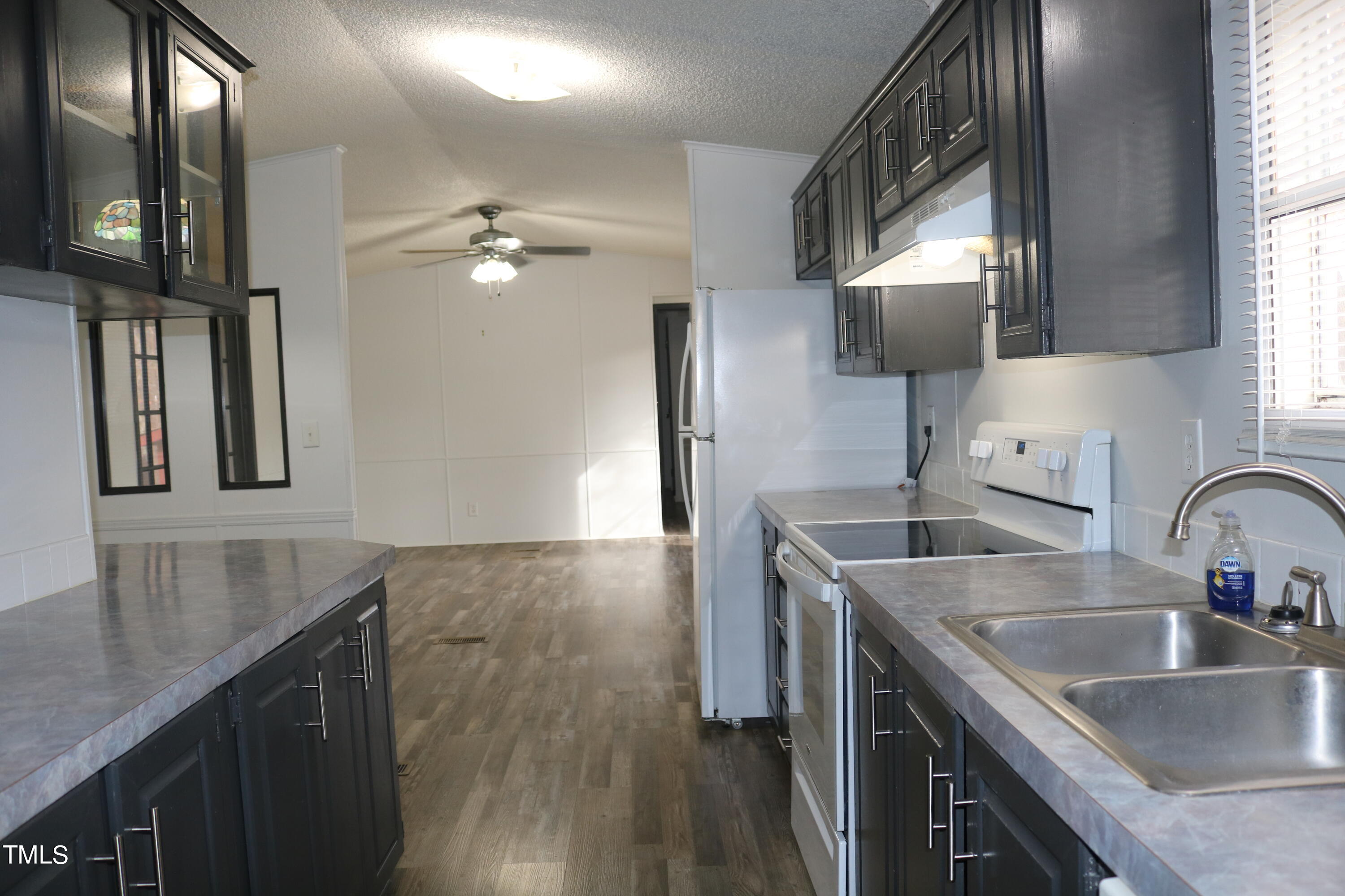 3537 Langston Road Raleigh, NC 27610 - Photo 5 of 21 a kitchen with a sink dishwasher a stove and a refrigerator with wooden floor