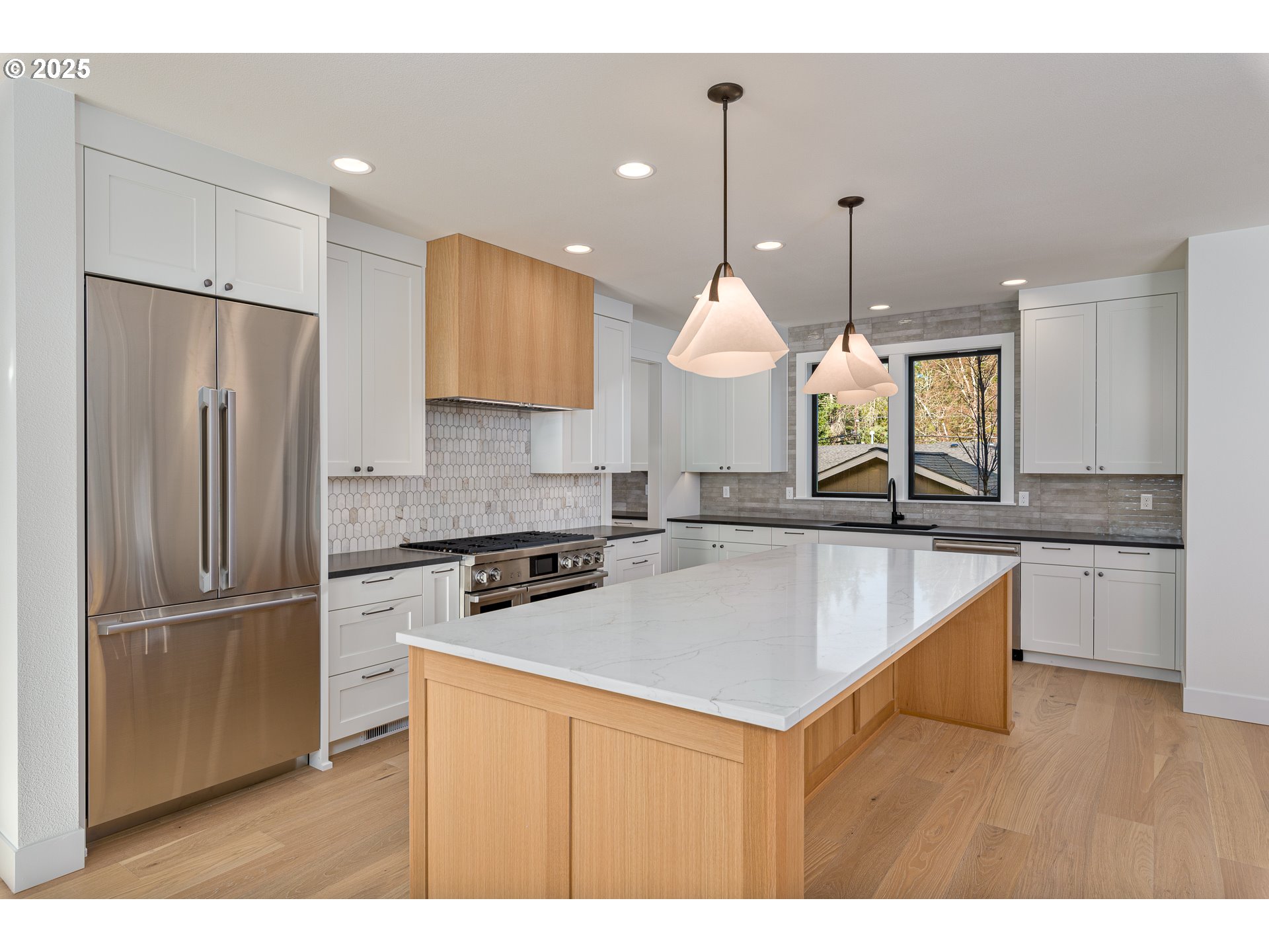 1855 Cloverleaf Road Lake Oswego, OR 97034 - Photo 7 of 34 a kitchen with stainless steel appliances granite countertop a sink a stove a refrigerator and island with wooden floor