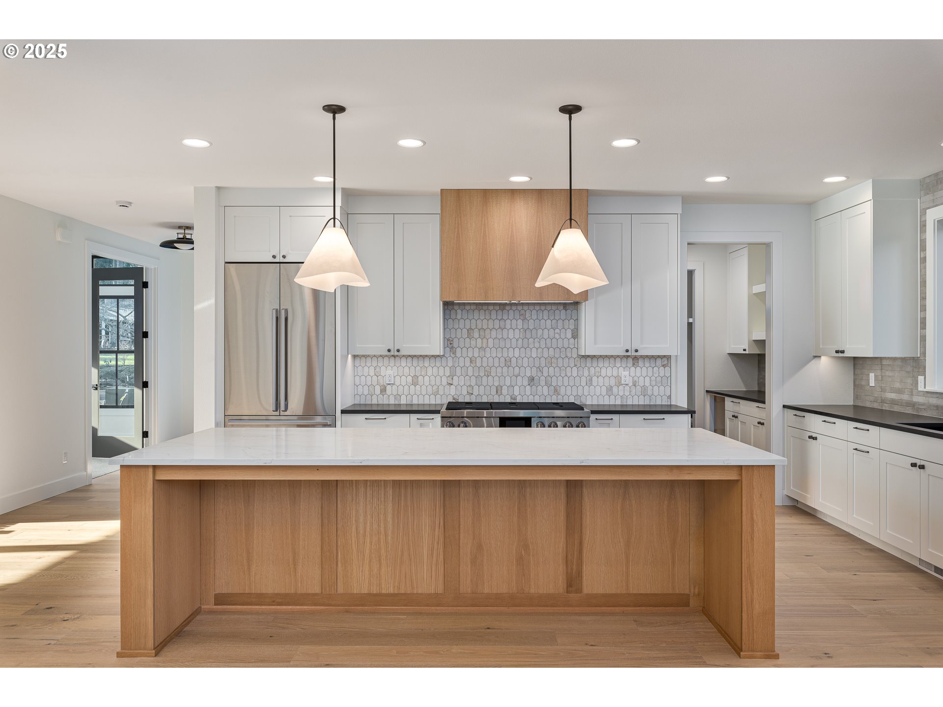 1855 Cloverleaf Road Lake Oswego, OR 97034 - Photo 8 of 34 a large kitchen with kitchen island a stove a sink a center island and a window