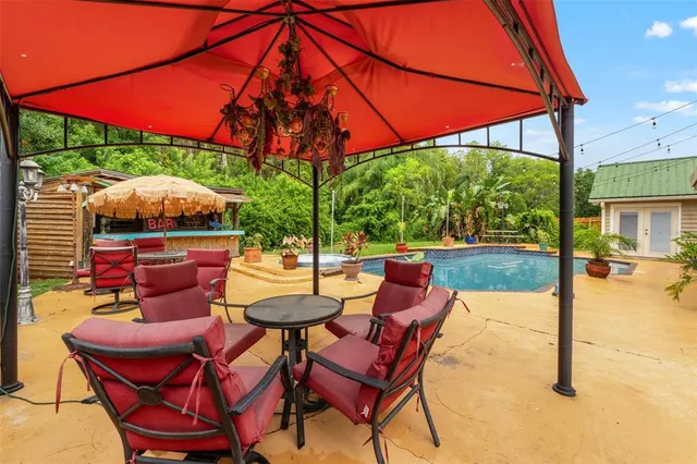 a view of a swimming pool with a yard and outdoor seating