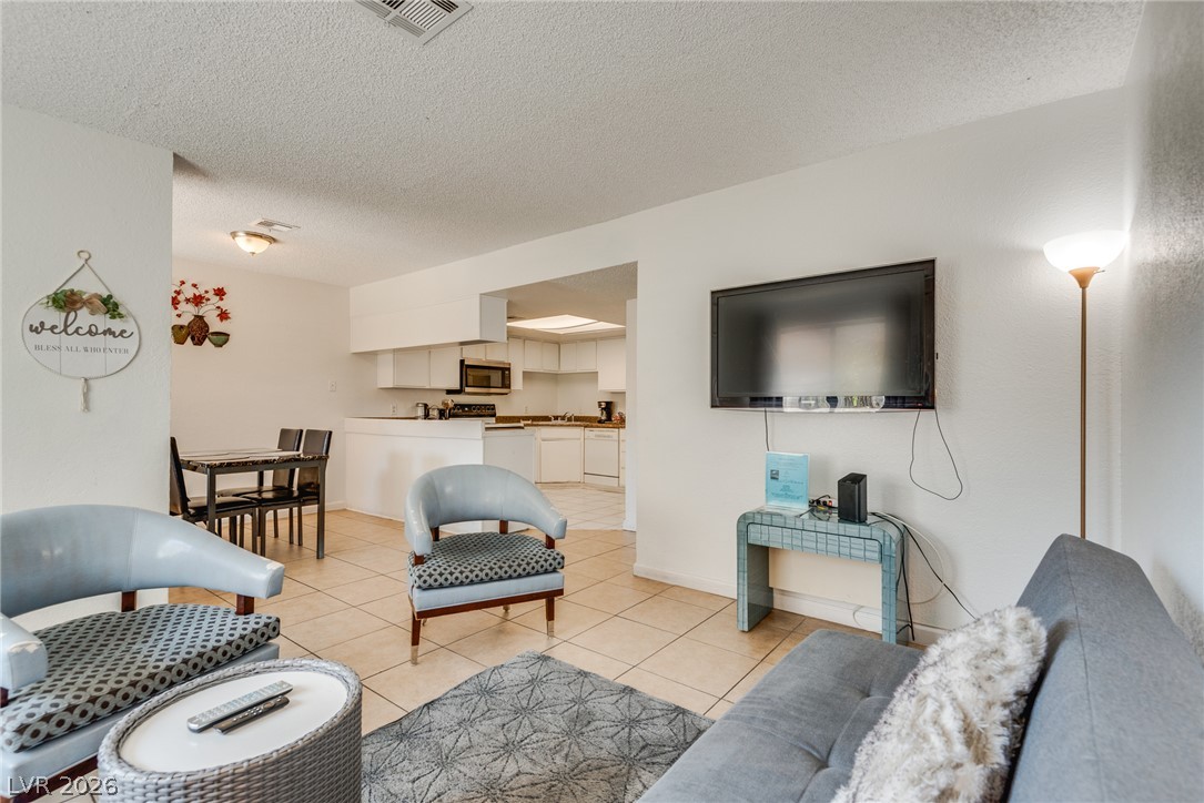 5829 Smoke Ranch Road, Unit D Las Vegas, NV 89108 - Photo 10 of 27 An open layout connects the tiled living space directly to the kitchen and dining area.