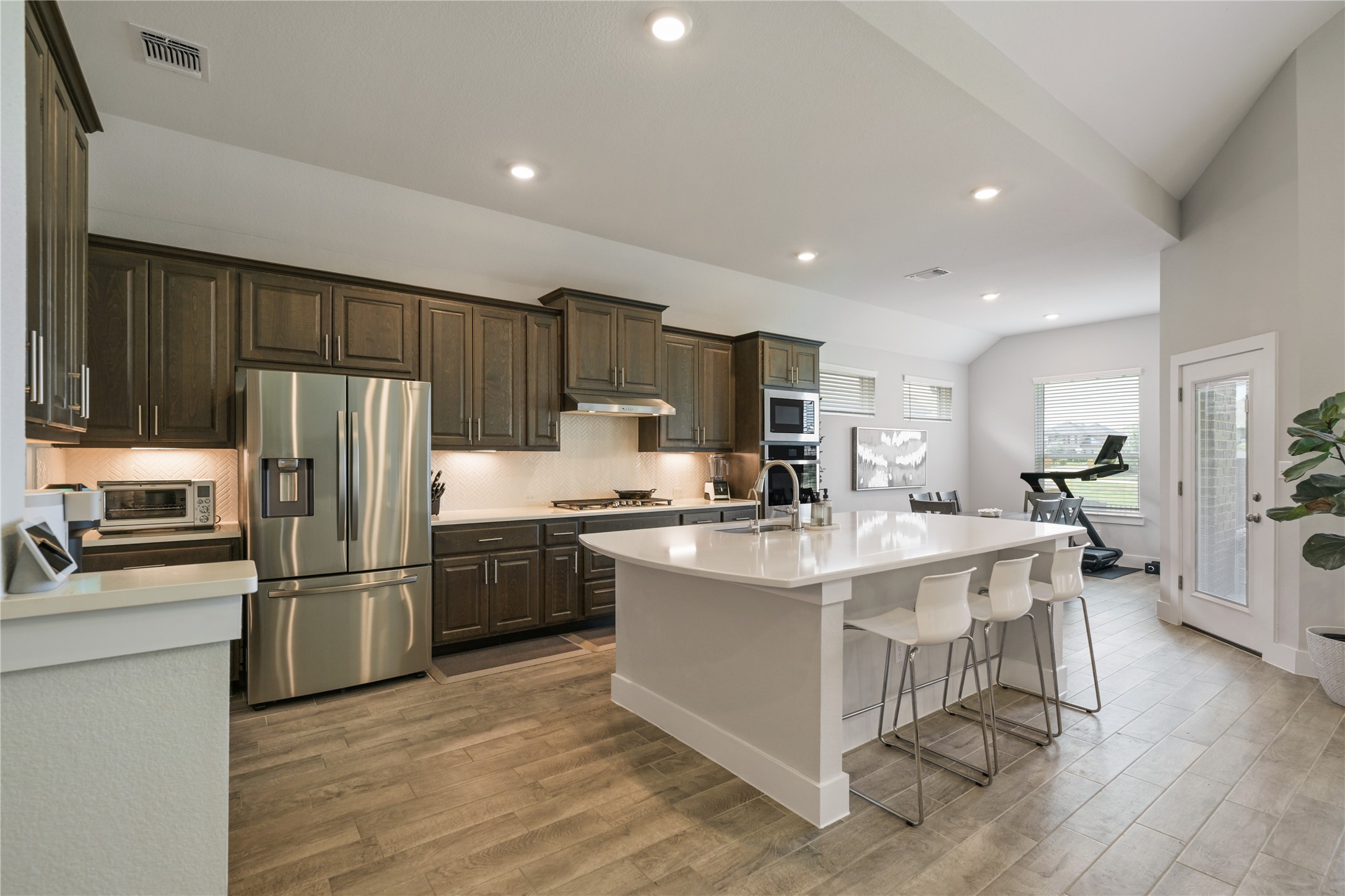 238 Wild Pecan Loop Buda, TX 78610 - Photo 8 of 31 Gleaming stone countertops and dark wood cabinetry define this open kitchen with tiled floors.