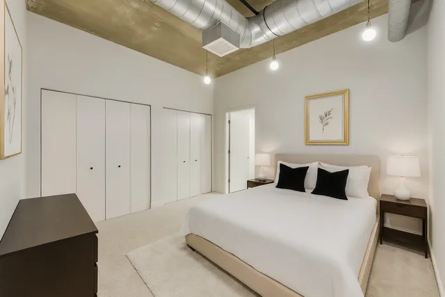 a bedroom with a bed and a painting on the wall