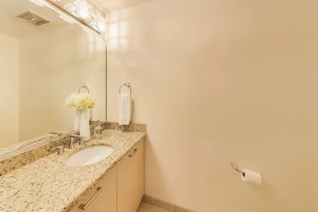 a bathroom with a granite countertop sink and a mirror