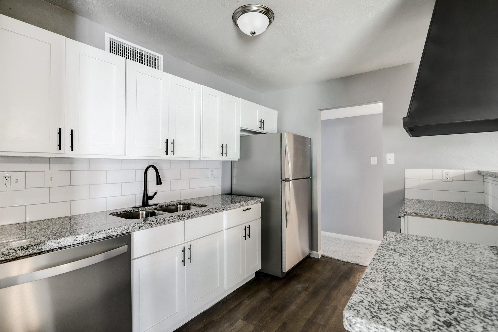 14107 Pinewest Drive Houston, TX 77049 - Photo 4 of 10 a kitchen with stainless steel appliances granite countertop a sink stove and refrigerator