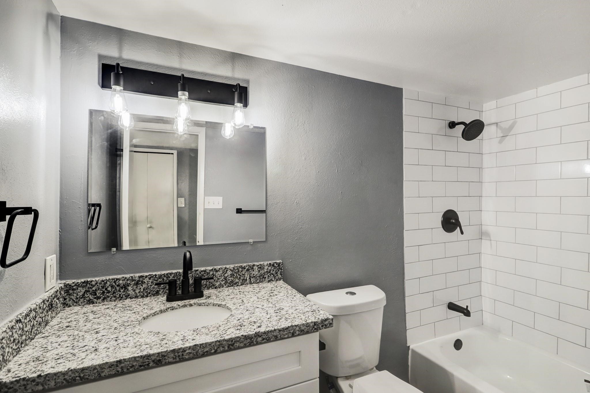 14107 Pinewest Drive Houston, TX 77049 - Photo 7 of 10 a bathroom with a granite countertop sink toilet and shower