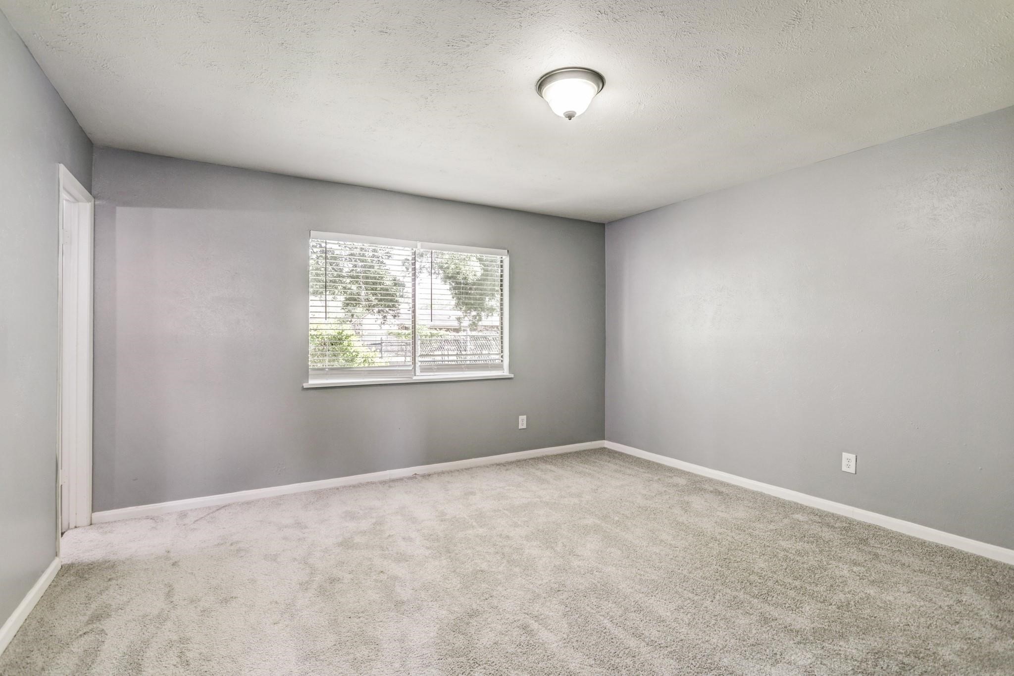 14107 Pinewest Drive Houston, TX 77049 - Photo 8 of 10 an empty room with windows