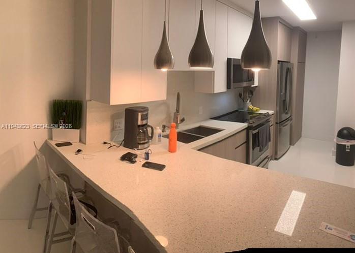 100 Lincoln Road, Unit 1535 Miami Beach, FL 33139 - Photo 5 of 6 a kitchen with stainless steel appliances a sink a stove and a refrigerator