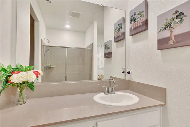 a bathroom with a granite countertop sink and a mirror