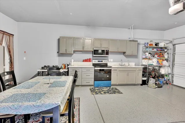 a kitchen with stainless steel appliances granite countertop a sink a stove a refrigerator and cabinets