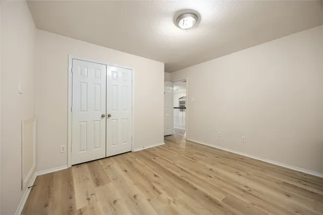 an empty room with wooden floor and closet