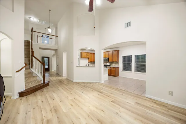 a view of an empty room with cabinet and windows