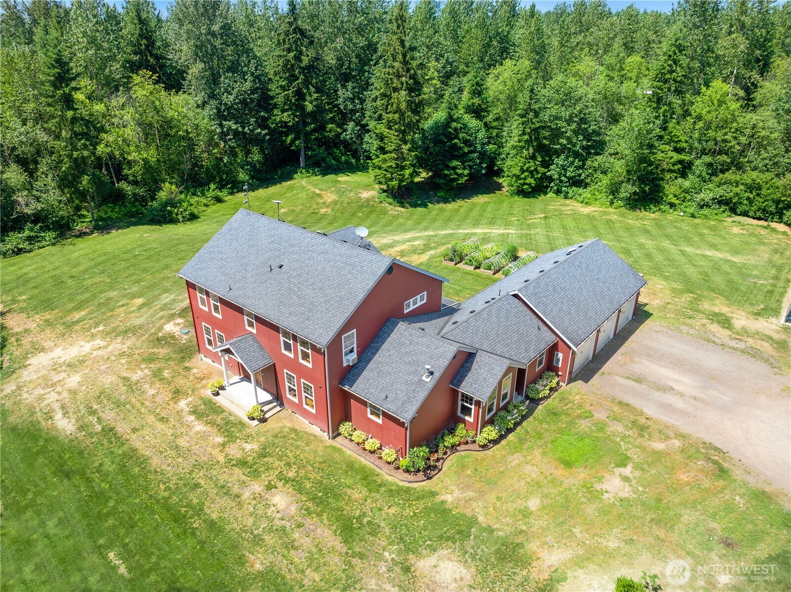 an aerial view of a house with pool and a yard