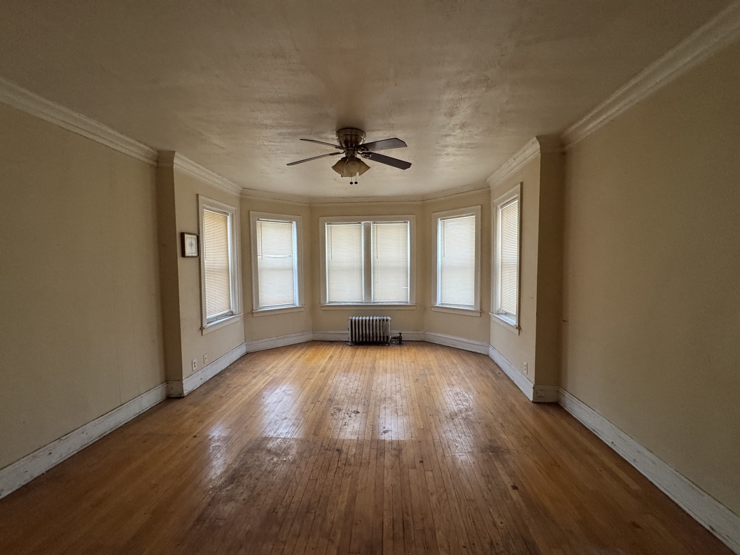 605 East 80th Street Chicago, IL 60619 - Photo 4 of 13 an empty room with wooden floor and windows