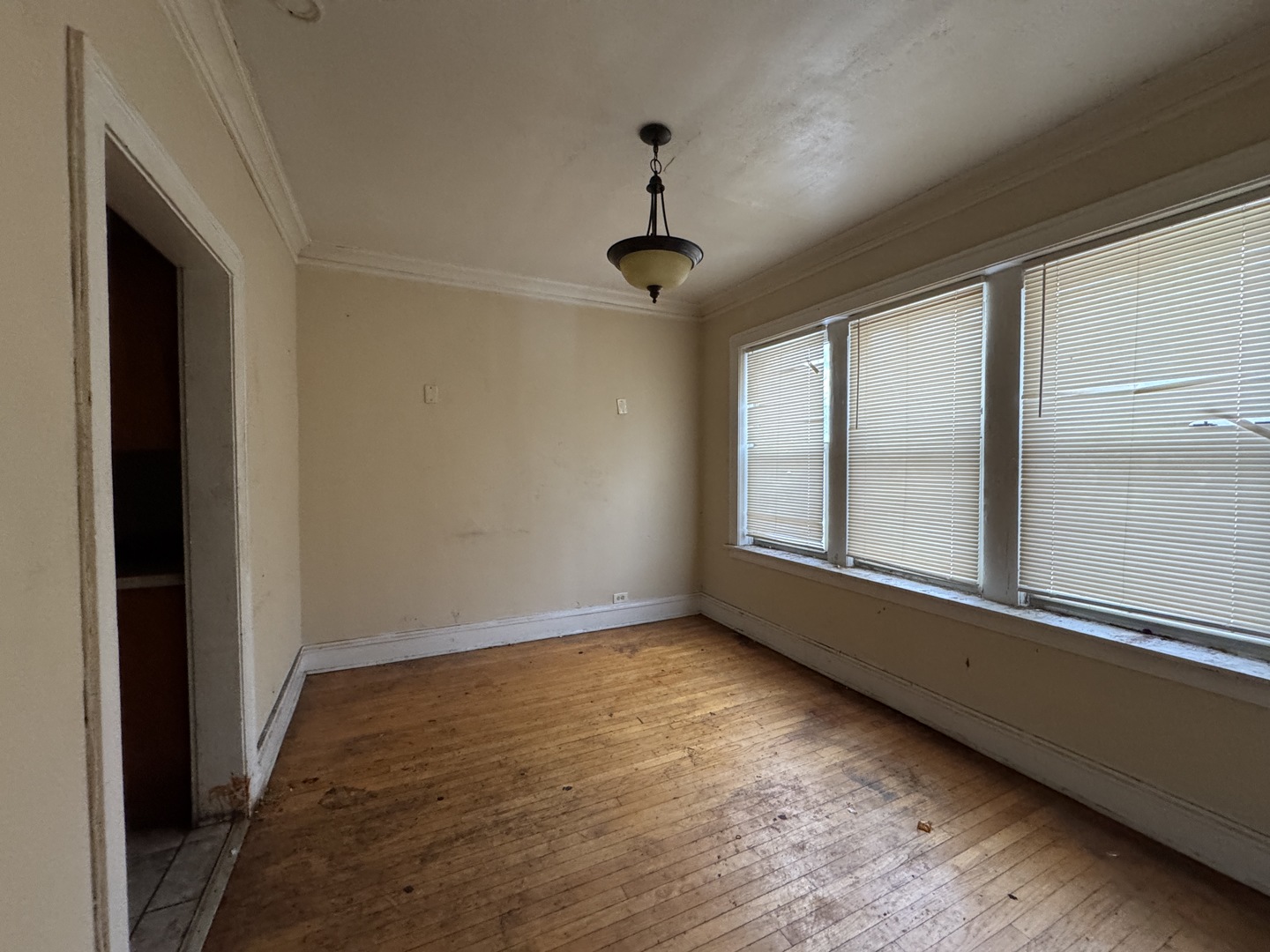 605 East 80th Street Chicago, IL 60619 - Photo 5 of 13 a view of an empty room with wooden floor and a window