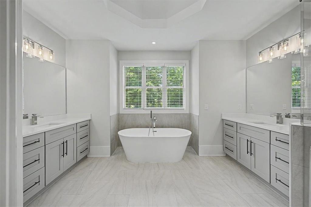 217 Laura Lake Road Marietta, GA 30066 - Photo 34 of 54 a spacious bathroom with a double vanity sink a large mirror and a bathtub