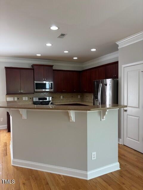 200 Presenteer Trail Apex, NC 27539 - Photo 5 of 17 a view of a kitchen with stainless steel appliances granite countertop a stove a refrigerator a sink a microwave and wooden floor