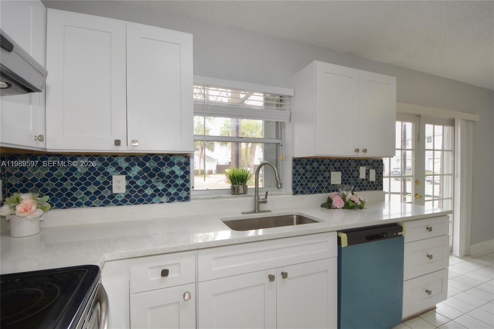 4801 Grapevine Way, Unit 4801 Davie, FL 33331 - Photo 11 of 32 a kitchen with white cabinets a sink a window and appliances