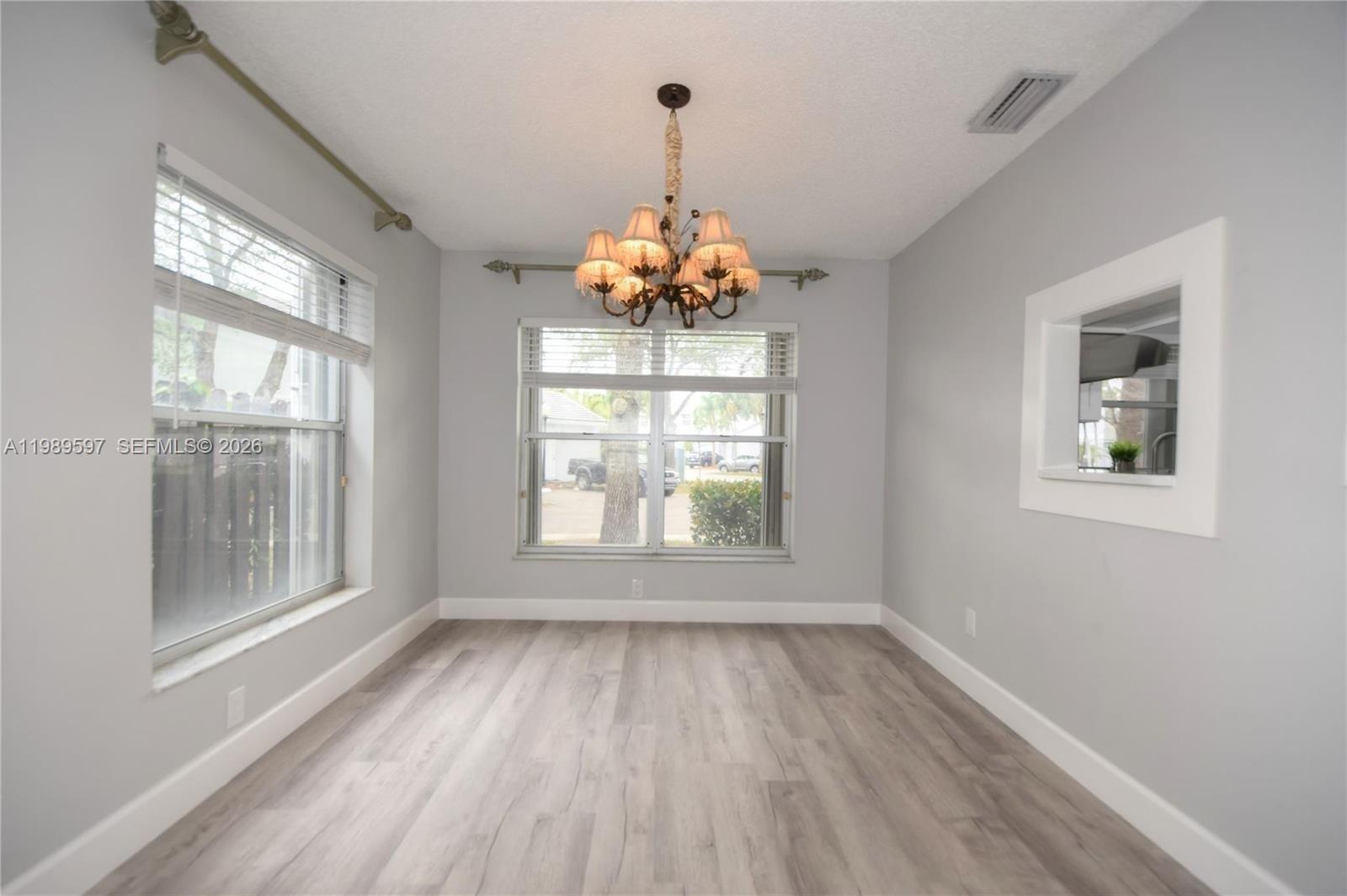 4801 Grapevine Way, Unit 4801 Davie, FL 33331 - Photo 6 of 32 wooden floor in an empty room with a window